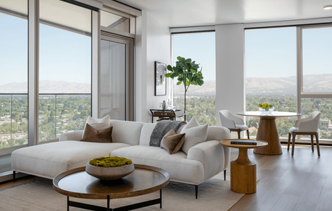 a living room with a white couch and views of the city and mountains